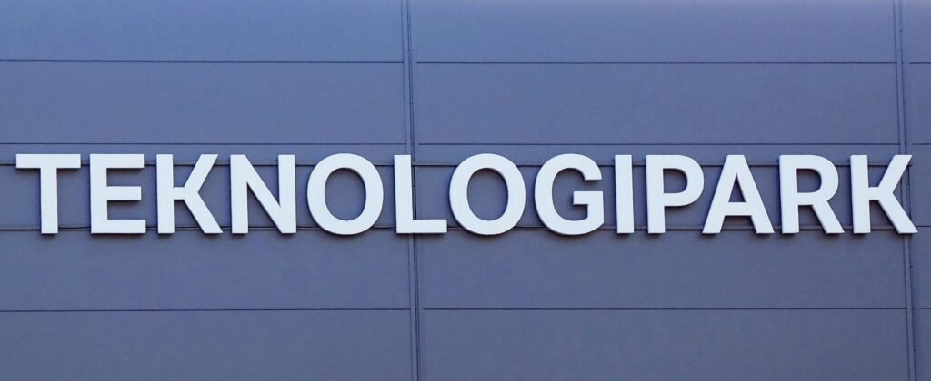 Gebäude mit einem Schild, auf dem 'teknologia park' steht, als Symbol für einen modernen Technologiepark.