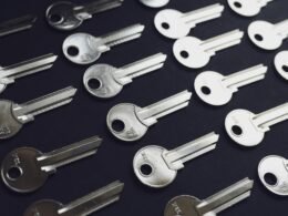 Mehrere klassische Schlüssel liegen gesammelt auf einer Holzoberfläche und symbolisieren Zugang und Sicherheit.