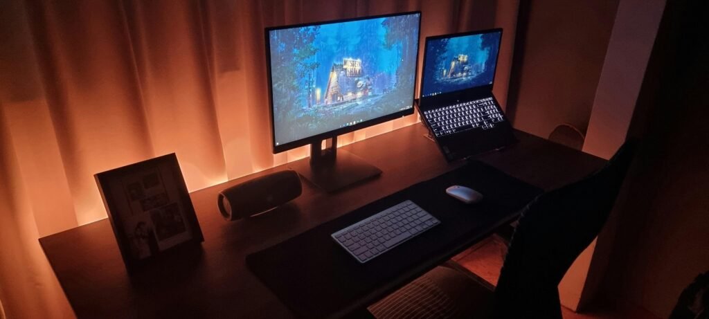 Ein Schreibtisch mit einem Computer und einem Laptop, ausgestattet für zeitgemäßes Arbeiten in einem modernen Büro.