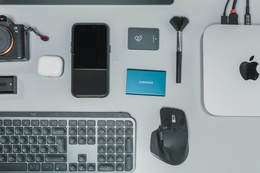 Schreibtisch mit Tastatur, Maus, Handy und weiteren Gegenständen für eine digitale Arbeitsumgebung