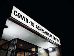 Schwarz-weißes Foto eines beleuchteten Gebäudes bei Nacht mit deutlich erkennbaren Fassadendetails