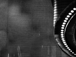 Schwarz-weißes Foto eines runden Spiegels auf neutralem Hintergrund, minimalistisch inszeniert