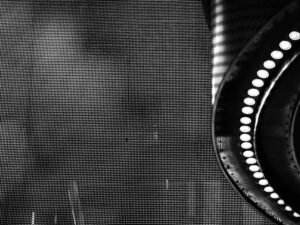 Schwarz-weißes Foto eines runden Spiegels auf neutralem Hintergrund, minimalistisch inszeniert