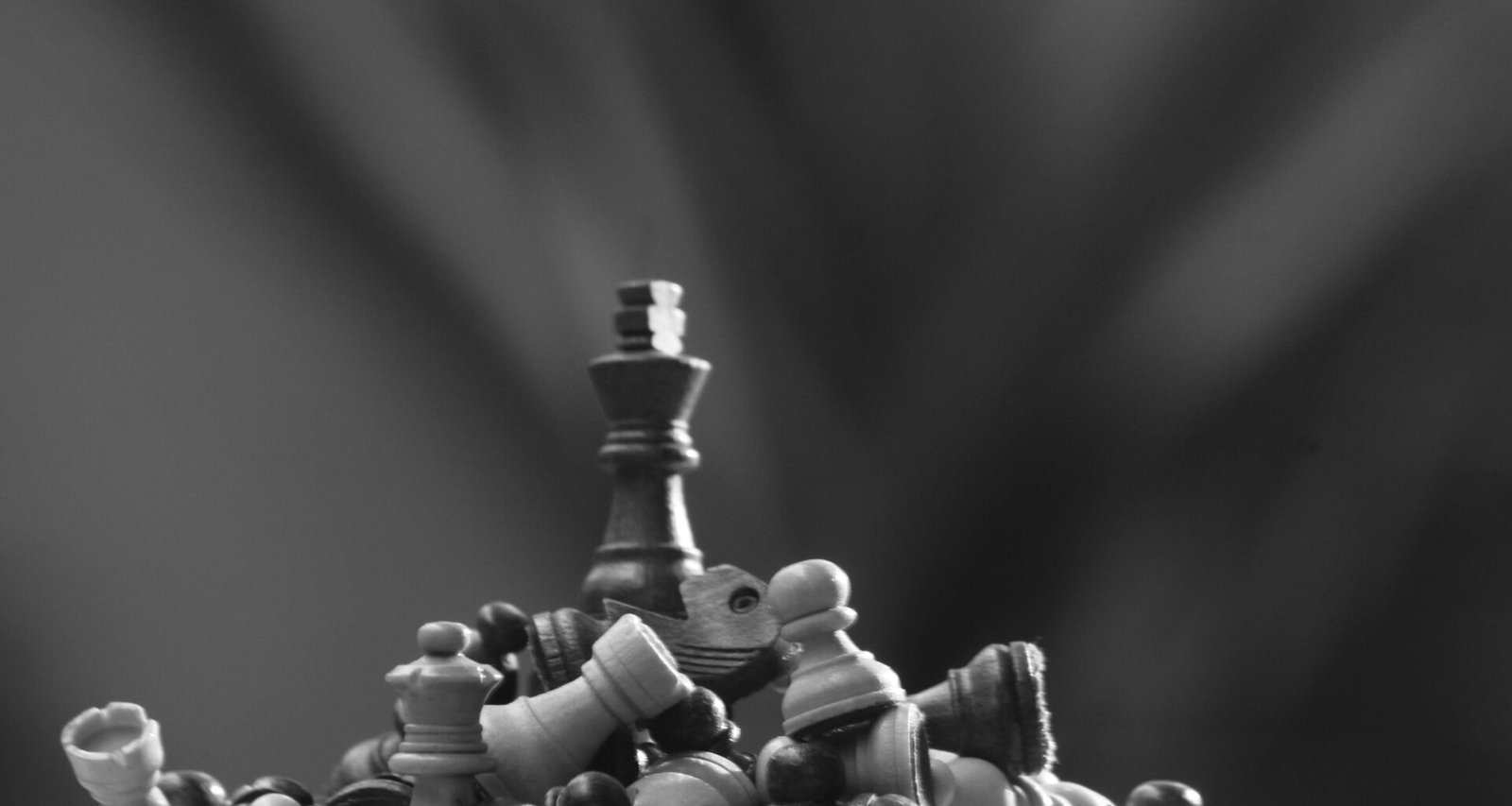 Schwarz-weiß Foto eines Schachbretts mit Figuren, deutlich zu sehen auf dem Spielfeld, ideal für Themen rund um Strategie