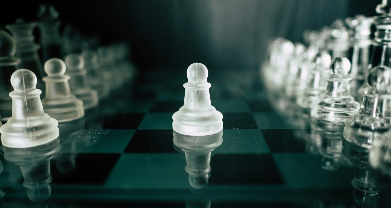 Schwarz-weißes Schachbrett mit weißen Figuren in der Vordergrundansicht, geeignet als Symbol für Strategie-Artikel