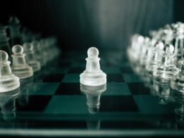 Schwarz-weißes Schachbrett mit weißen Figuren in der Vordergrundansicht, geeignet als Symbol für Strategie-Artikel