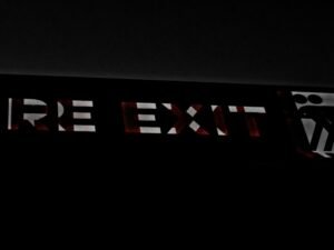 Schwarz-weißes Schild mit klaren Linien, abgebildet vor neutralem Hintergrund, fotografiert von TRG