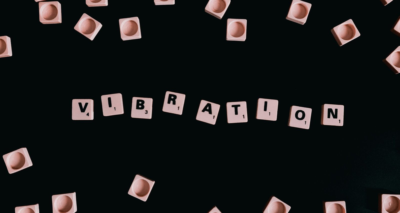 Schwarzer Hintergrund, darauf Würfel mit Buchstaben, die das Wort Vibration ergeben, abstrahiertes Technikmotiv