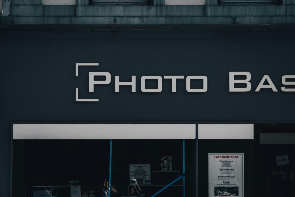 Modernes schwarzes Gebäude mit Leuchtschild 'photo bask' an der Fassade, aufgenommen bei Tag