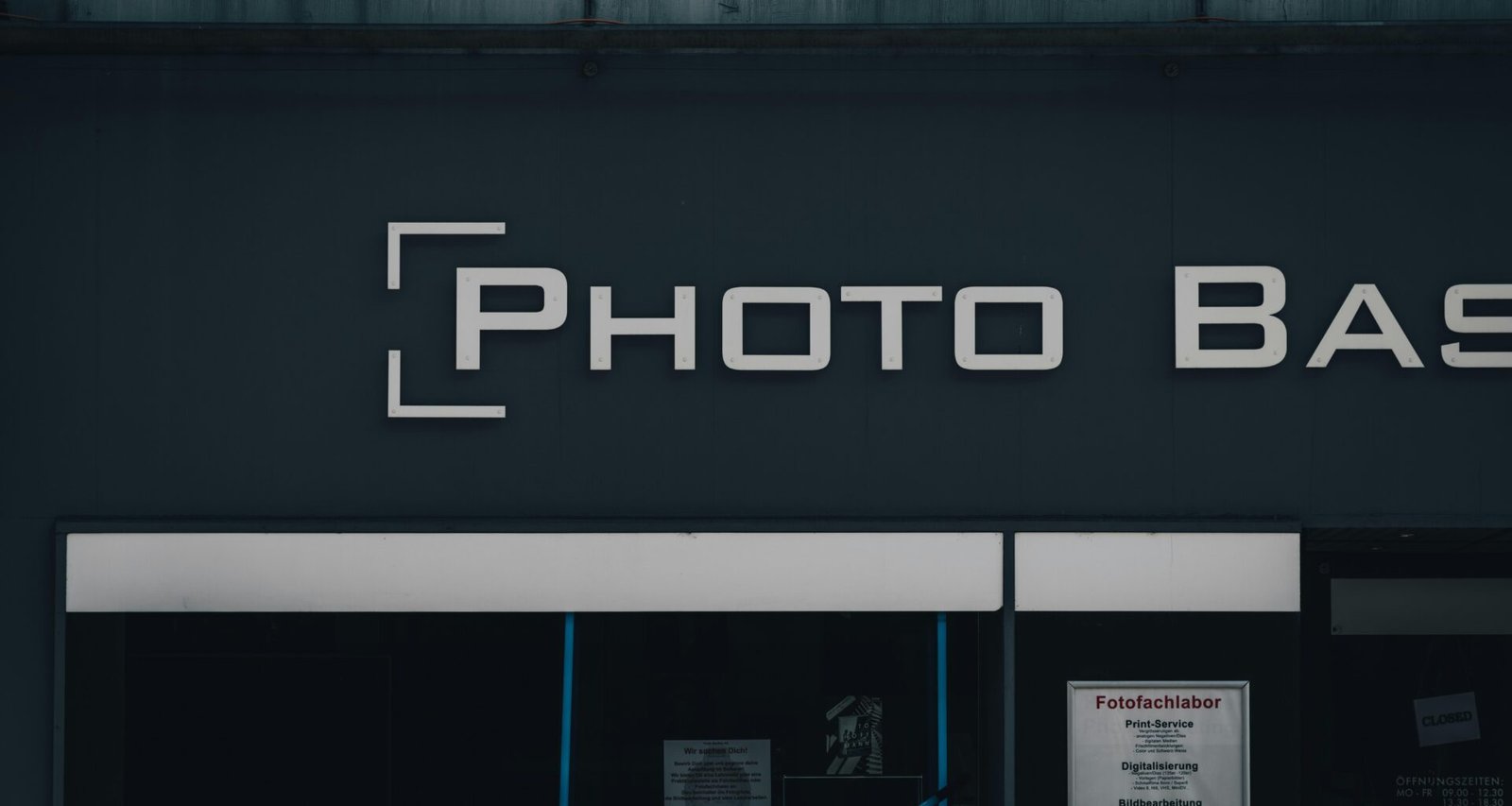 Modernes schwarzes Gebäude mit Leuchtschild 'photo bask' an der Fassade, aufgenommen bei Tag
