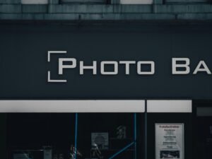 Modernes schwarzes Gebäude mit Leuchtschild 'photo bask' an der Fassade, aufgenommen bei Tag