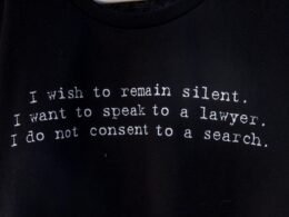 Schwarzes T-Shirt mit aufgedrucktem Gedicht liegt flach auf hellem Untergrund, aufgenommen von Dulcey Lima.