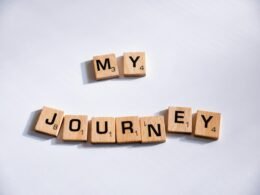 Nahaufnahme von Scrabble-Buchstaben, die die Worte 'My Journey' auf einem Spielbrett zusammensetzen.