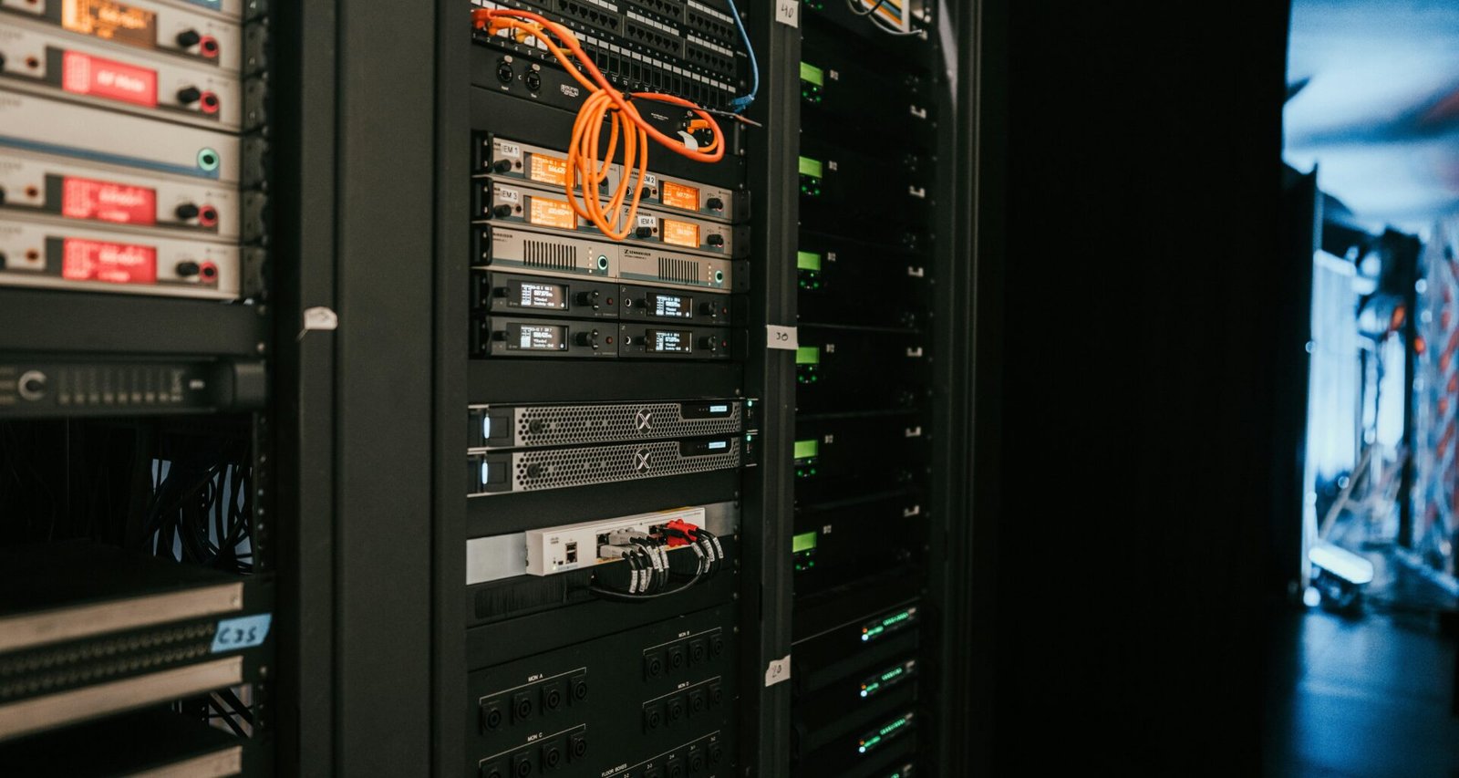 Reihe moderner Server-Racks in einem professionellen Serverraum mit strukturiertem Kabelmanagement, fotografiert von Kevin Ache