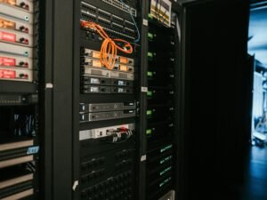 Reihe moderner Server-Racks in einem professionellen Serverraum mit strukturiertem Kabelmanagement, fotografiert von Kevin Ache