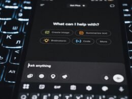 Ein Smartphone mit geöffneter KI-Assistenten-Oberfläche liegt auf einem Tisch und zeigt moderne Technologie.