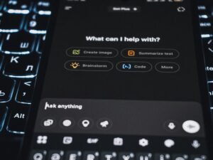Ein Smartphone mit geöffneter KI-Assistenten-Oberfläche liegt auf einem Tisch und zeigt moderne Technologie.