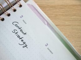 Ein Spiralnotizbuch, darauf ein Notizblock und ein Stift, arrangiert für strukturierte Notizen am Arbeitsplatz.