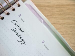 Ein Spiralnotizbuch, darauf ein Notizblock und ein Stift, arrangiert für strukturierte Notizen am Arbeitsplatz.