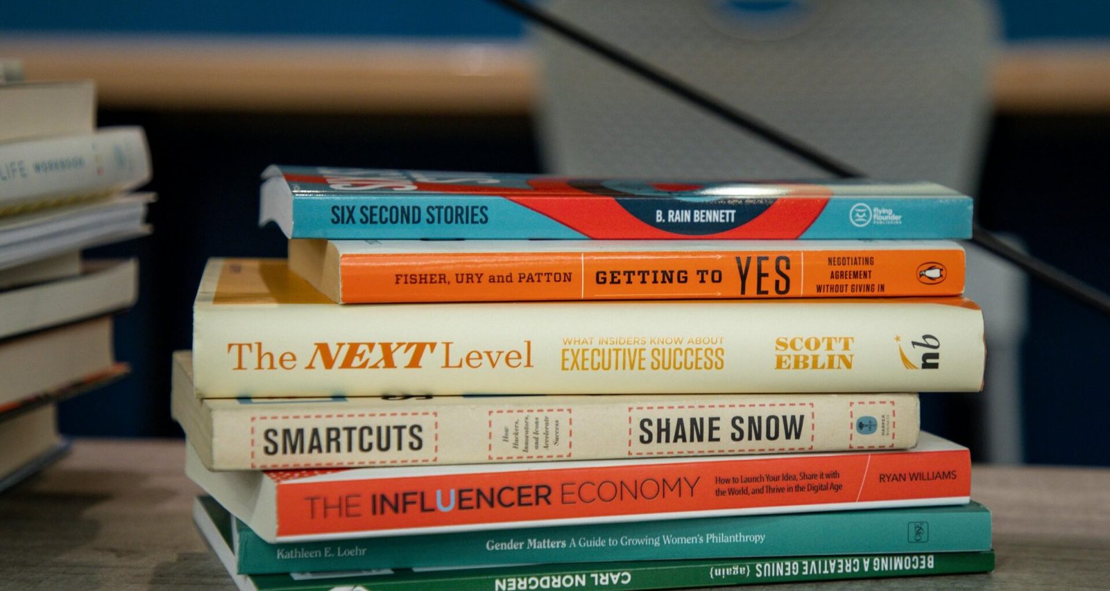 Ein Stapel verschieden großer Bücher liegt ordentlich auf einem Holztisch und bietet Inspiration für Online-Marketing-Themen.