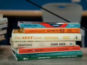 Ein Stapel verschieden großer Bücher liegt ordentlich auf einem Holztisch und bietet Inspiration für Online-Marketing-Themen.