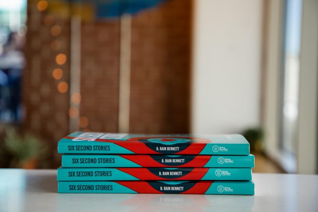 Ein Stapel aus drei Büchern liegt ordentlich auf einem Holztisch, geeignet für Themen rund um Technik und Online-Marketing.