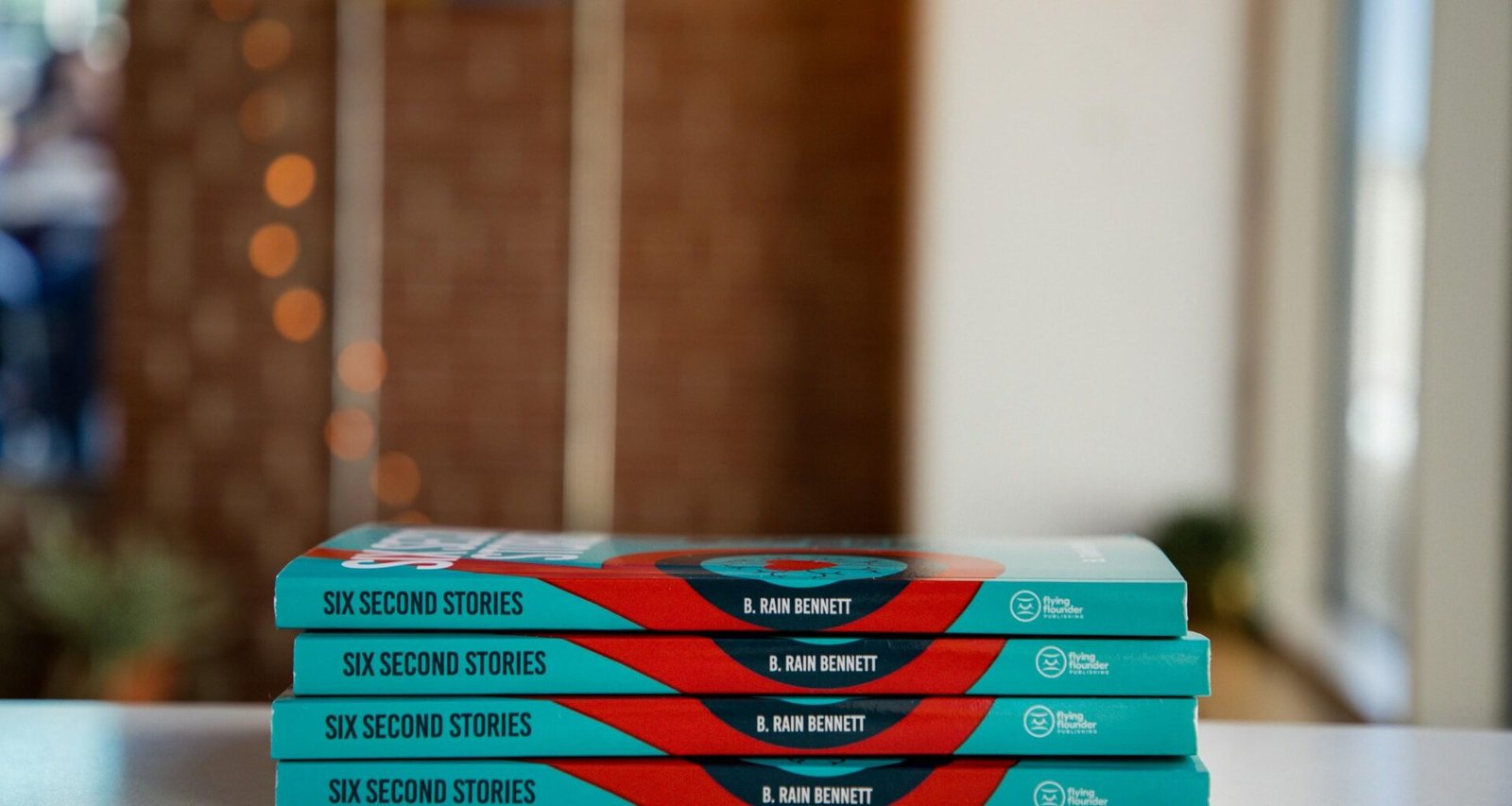 Ein Stapel aus drei übereinanderliegenden Büchern auf einem Holztisch, Fokus auf Lernen und Information