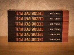 Fünf Bücher liegen gestapelt auf einem Holz­tisch. Symbol für Wissen und Weiterbildung im digitalen Umfeld.