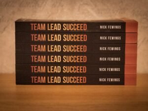 Fünf Bücher liegen gestapelt auf einem Holz­tisch. Symbol für Wissen und Weiterbildung im digitalen Umfeld.