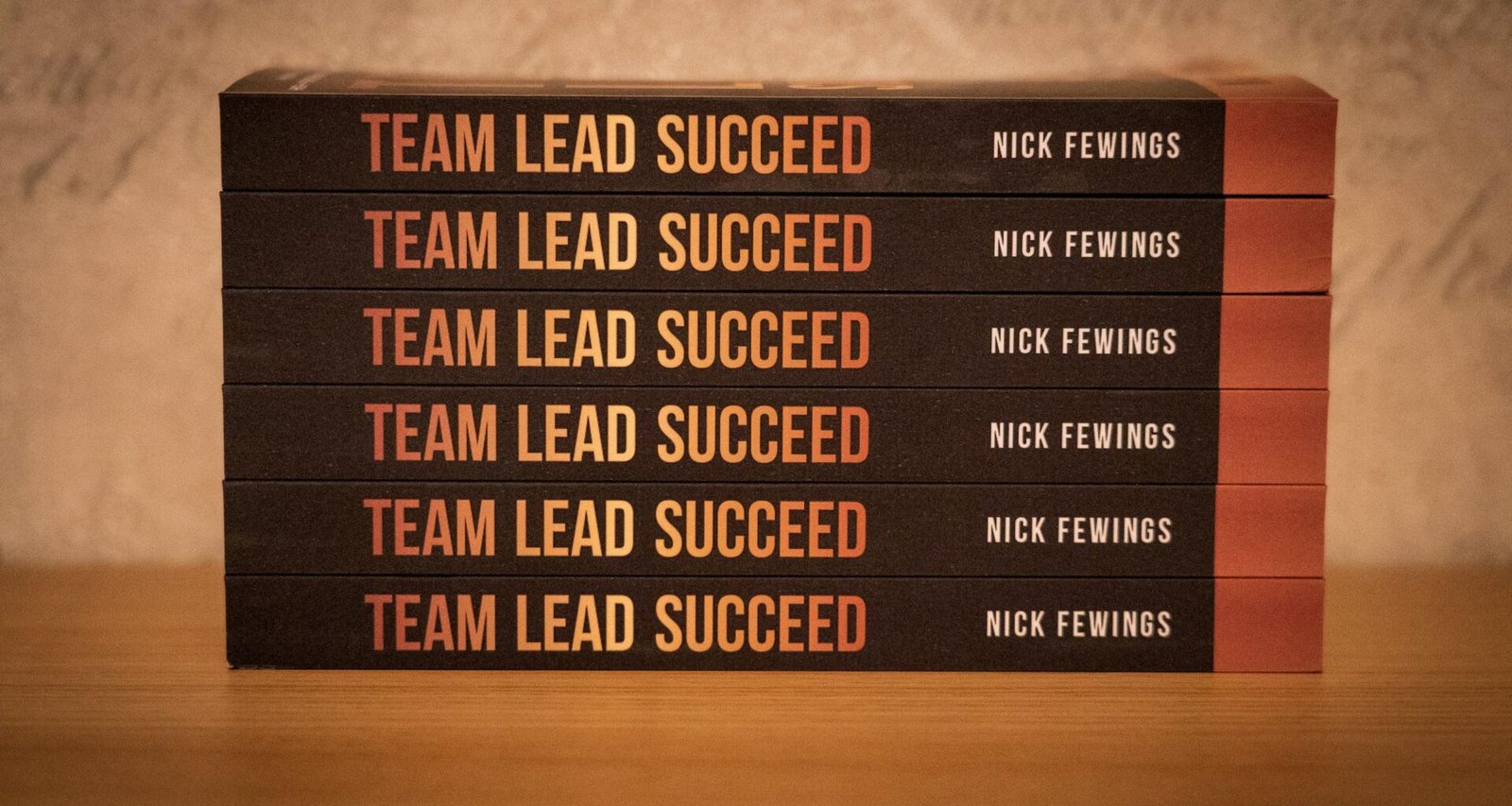 Ein Stapel von fünf Büchern steht ordentlich auf einem Holz­tisch. Das Bild verdeutlicht Lernbereitschaft im digitalen Umfeld.