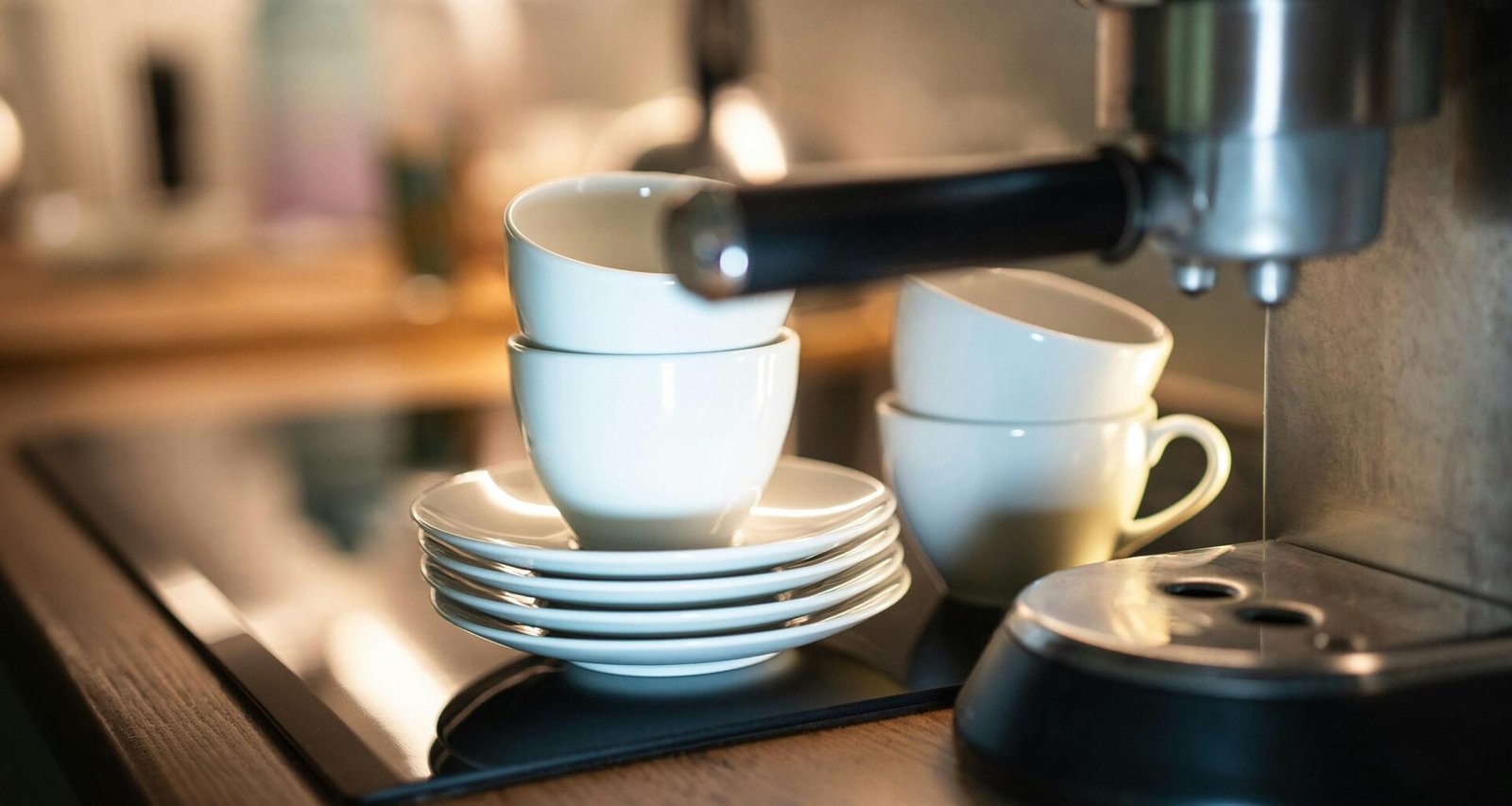 Ein Stapel weißer Kaffeetassen auf einer Theke, aufgenommen aus der Seitenansicht in heller Umgebung