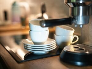 Ein Stapel weißer Kaffeetassen auf einer Theke, aufgenommen aus der Seitenansicht in heller Umgebung