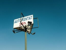 Straßenschild vor wolkenlosem Himmel, das als Metapher für Navigation und Wegweisung dient