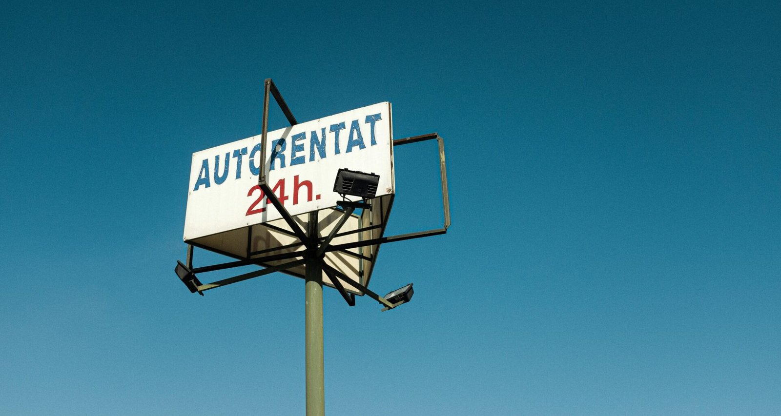 Ein Straßenschild steht vor einem bewölkten blauen Himmel – Symbol für Navigation und Richtung im urbanen Raum