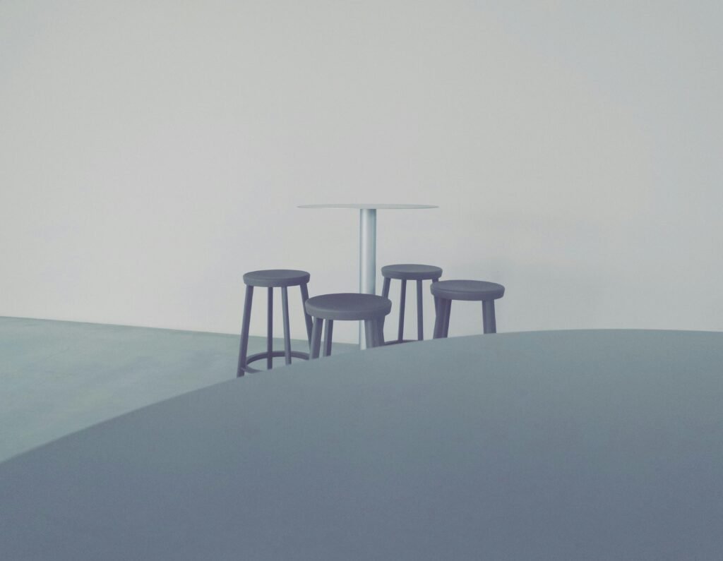 Ein moderner Stuhl steht auf festem Boden vor einem ruhigen Gewässer, aufgenommen bei Tageslicht in natürlicher Umgebung.