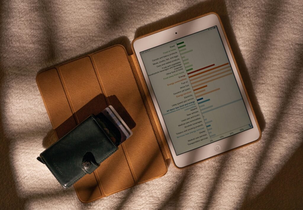 Tablet-Computer auf Tisch neben einer Geldbörse, Nahaufnahme, symbolisiert digitale und finanzielle Aspekte im Alltag.