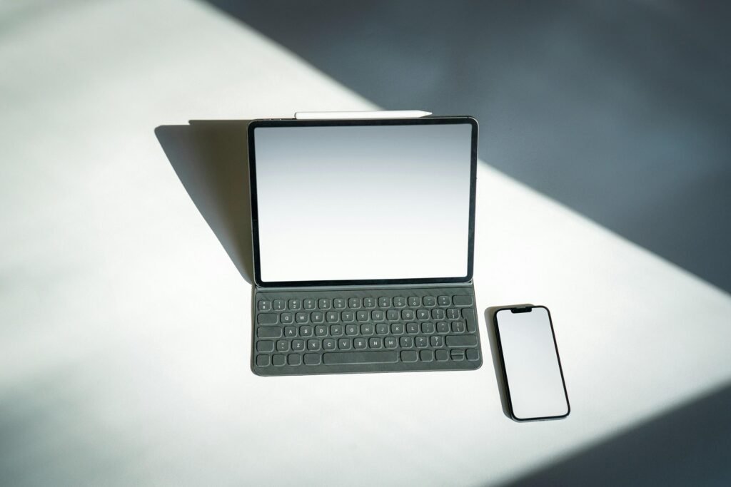 Ein Tablet und ein Smartphone liegen nebeneinander auf einem Tisch, wichtige Tools für digitales Arbeiten und Kommunikation.