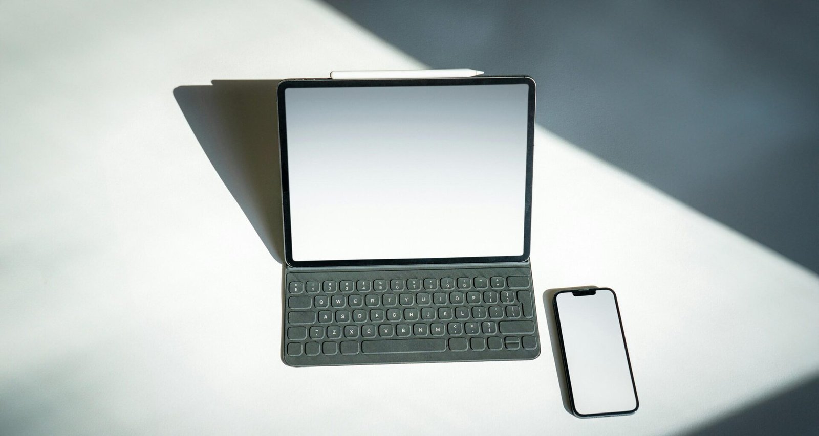 Ein Tablet und ein Smartphone liegen nebeneinander auf einem Tisch, wichtige Tools für digitales Arbeiten und Kommunikation.