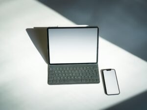 Ein Tablet und ein Smartphone liegen nebeneinander auf einem Tisch, wichtige Tools für digitales Arbeiten und Kommunikation.