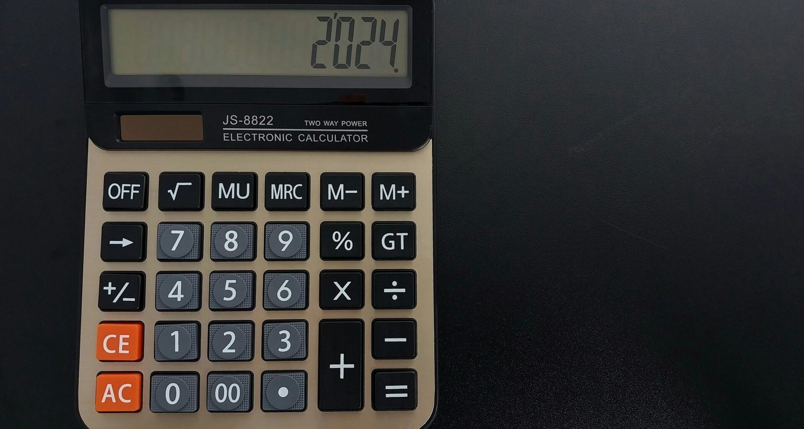 Ein moderner Taschenrechner liegt auf einem hellen Holztisch und ist bereit für Berechnungen im Büroalltag.