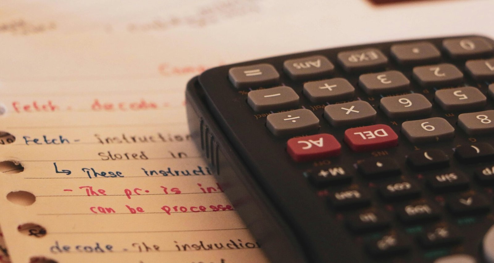 Ein Taschenrechner ruht auf einem Blatt Papier mit Notizen – Detailaufnahme für Themen rund um Kalkulation und Analyse.