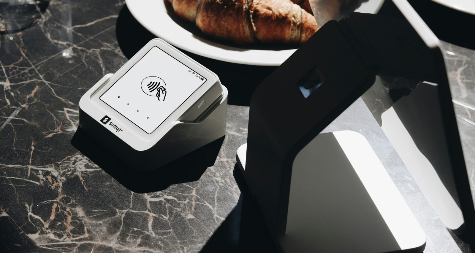 Ein gedeckter Tisch mit Tellern voller Speisen und einem Laptop, arrangiert als Arbeitsplatz und Essplatz zugleich