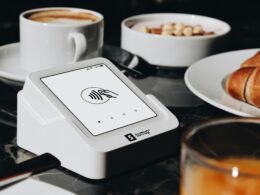 Ein gedeckter Tisch mit Tellern voller Speisen und mehreren Kaffeetassen, aufgenommen in moderner Umgebung