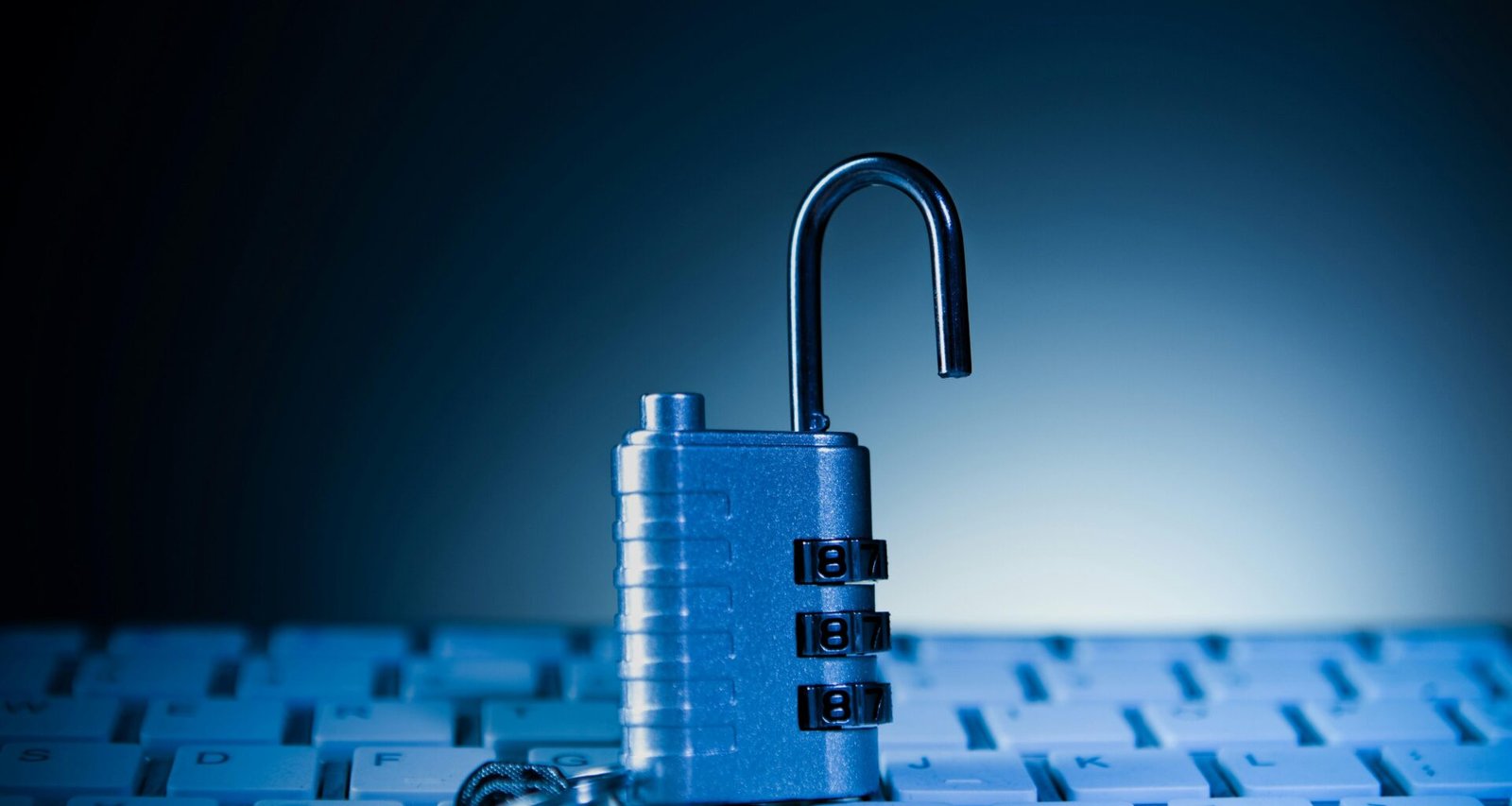 Ein geöffnetes Vorhängeschloss liegt auf einer Computer-Tastatur und steht für IT-Sicherheit und Datenschutz.