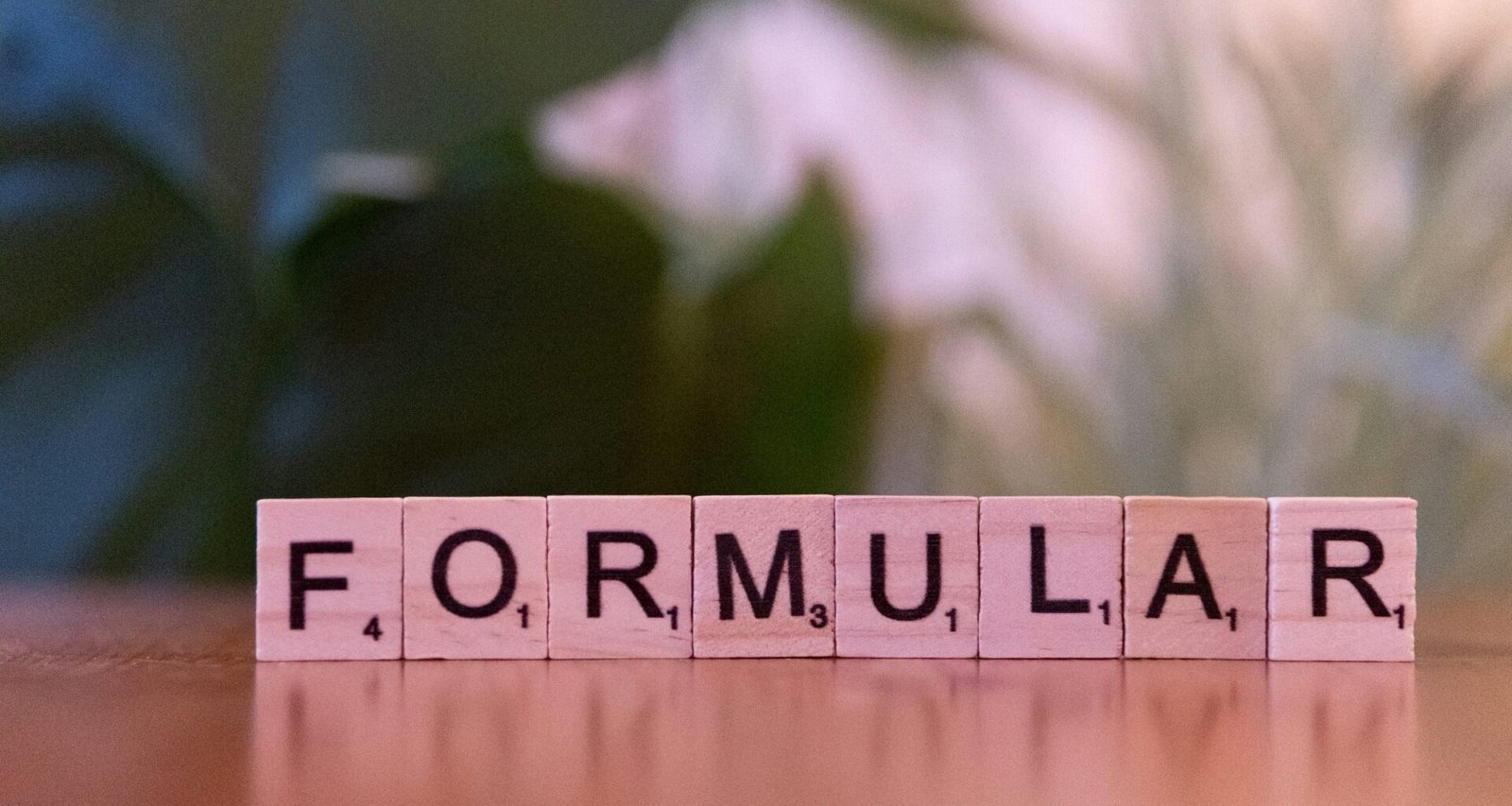 Scrabble-Steine auf Holz, die das Wort Formel ergeben, passend für Beiträge zu Logik, Struktur oder Strategie in Online-Themen