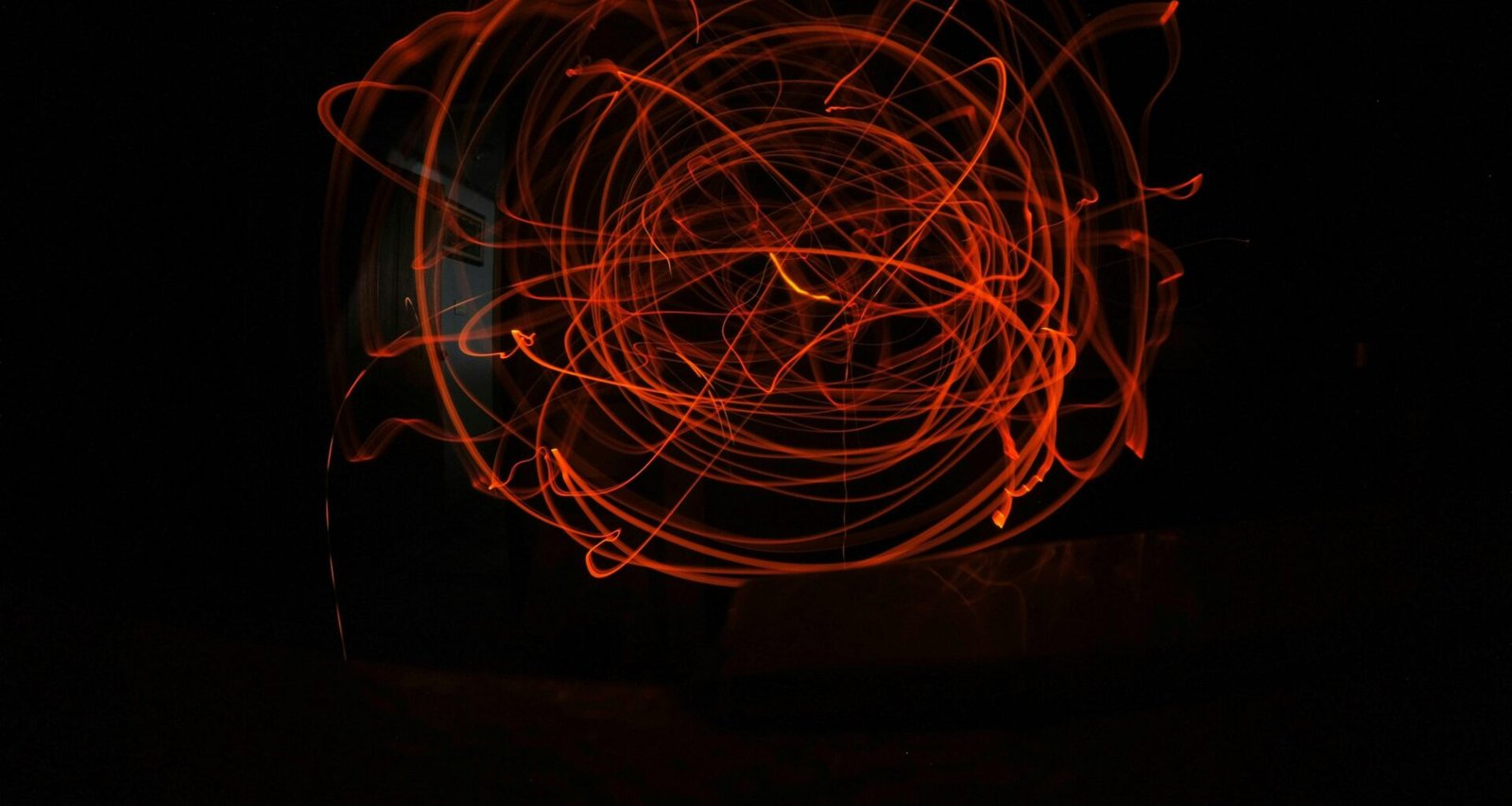 Verschwommenes rotes Objekt vor dunklem Hintergrund, modernes Beispiel für kreative Fotografie