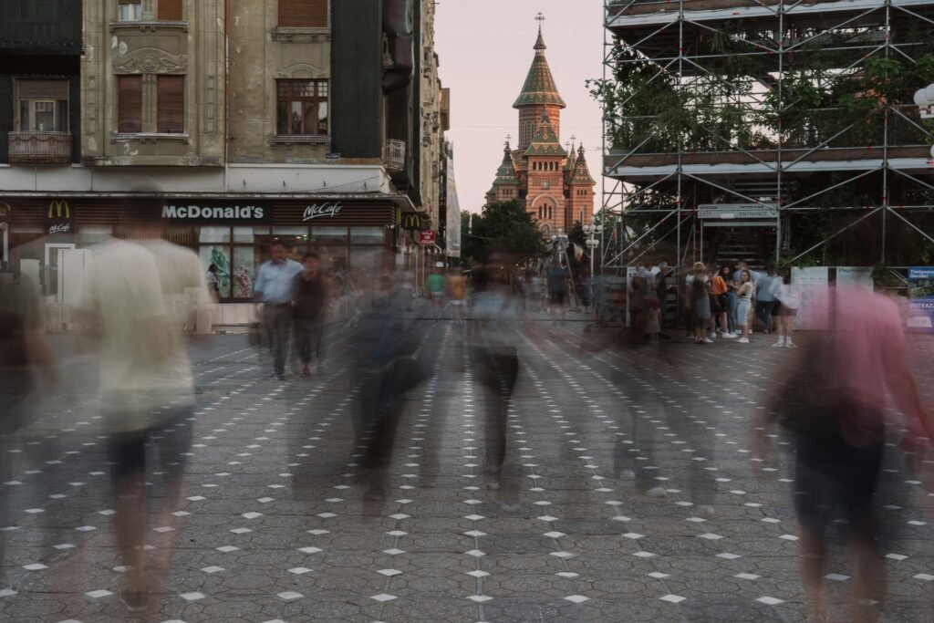 Verschwommene Aufnahme von mehreren Personen, die auf einer geschäftigen Straße entlanggehen, tagsüber in der Stadt