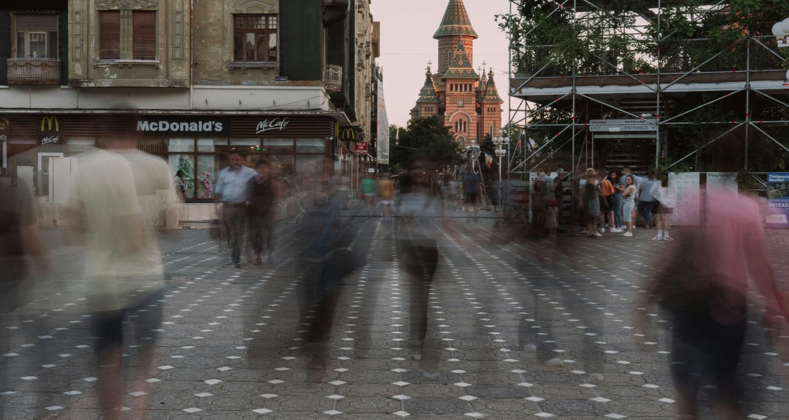 Verschwommene Aufnahme von mehreren Personen, die auf einer geschäftigen Straße entlanggehen, tagsüber in der Stadt