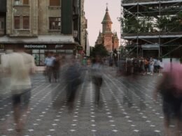 Verschwommene Aufnahme von mehreren Personen, die auf einer geschäftigen Straße entlanggehen, tagsüber in der Stadt