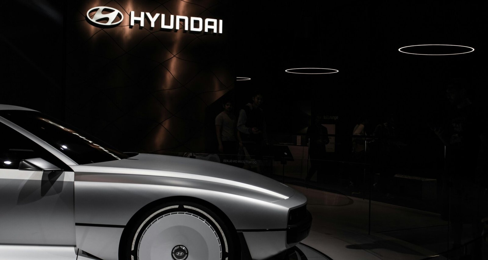 Ein weißes Auto steht geparkt in einem hell beleuchteten Ausstellungsraum und zeigt modernes Karosseriedesign.